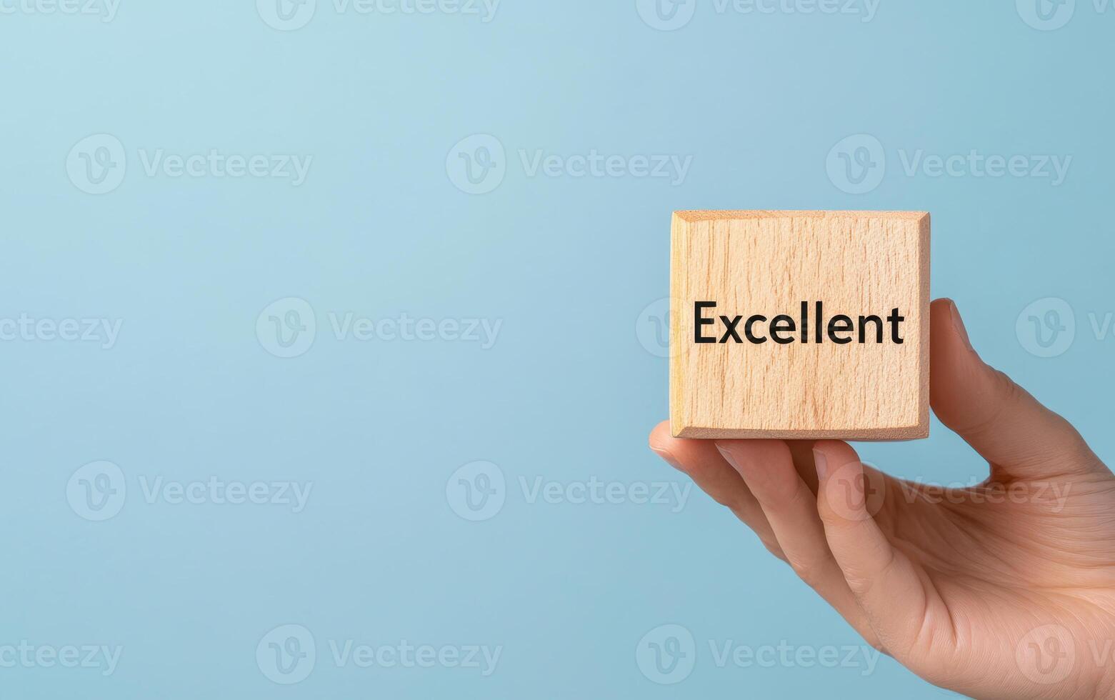 Wooden cube with Excellent rating held against blue background, symbolizing quality and achievement photo