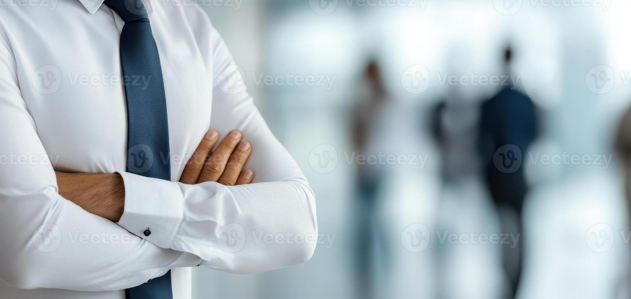 Business professional with crossed arms in modern office setting, conveying confidence and focus while discussing important matters photo