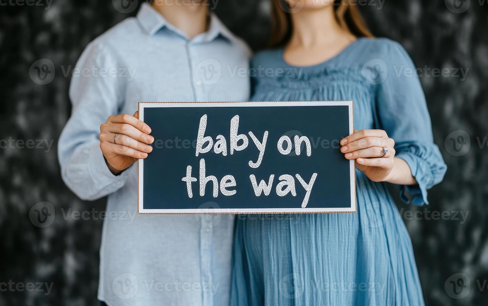 Couple holding sign that says baby on way with joy and anticipation. Expecting parents celebrate their upcoming arrival photo