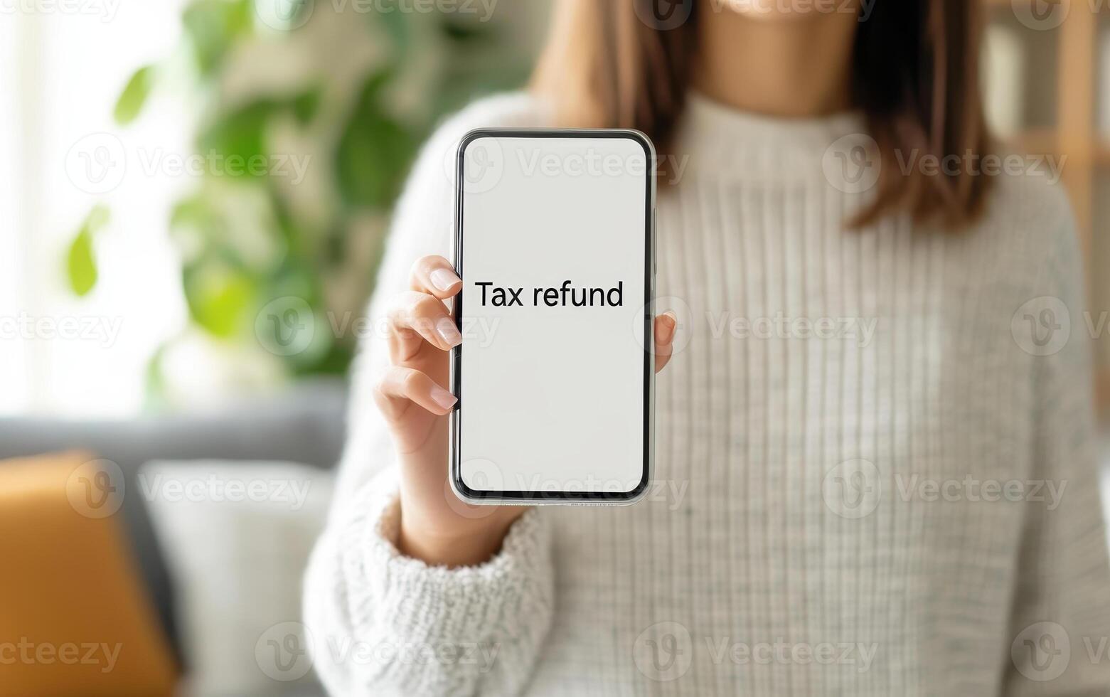 Smiling woman holding smartphone displaying tax refund information, showcasing excitement and relief. Perfect for financial themes photo
