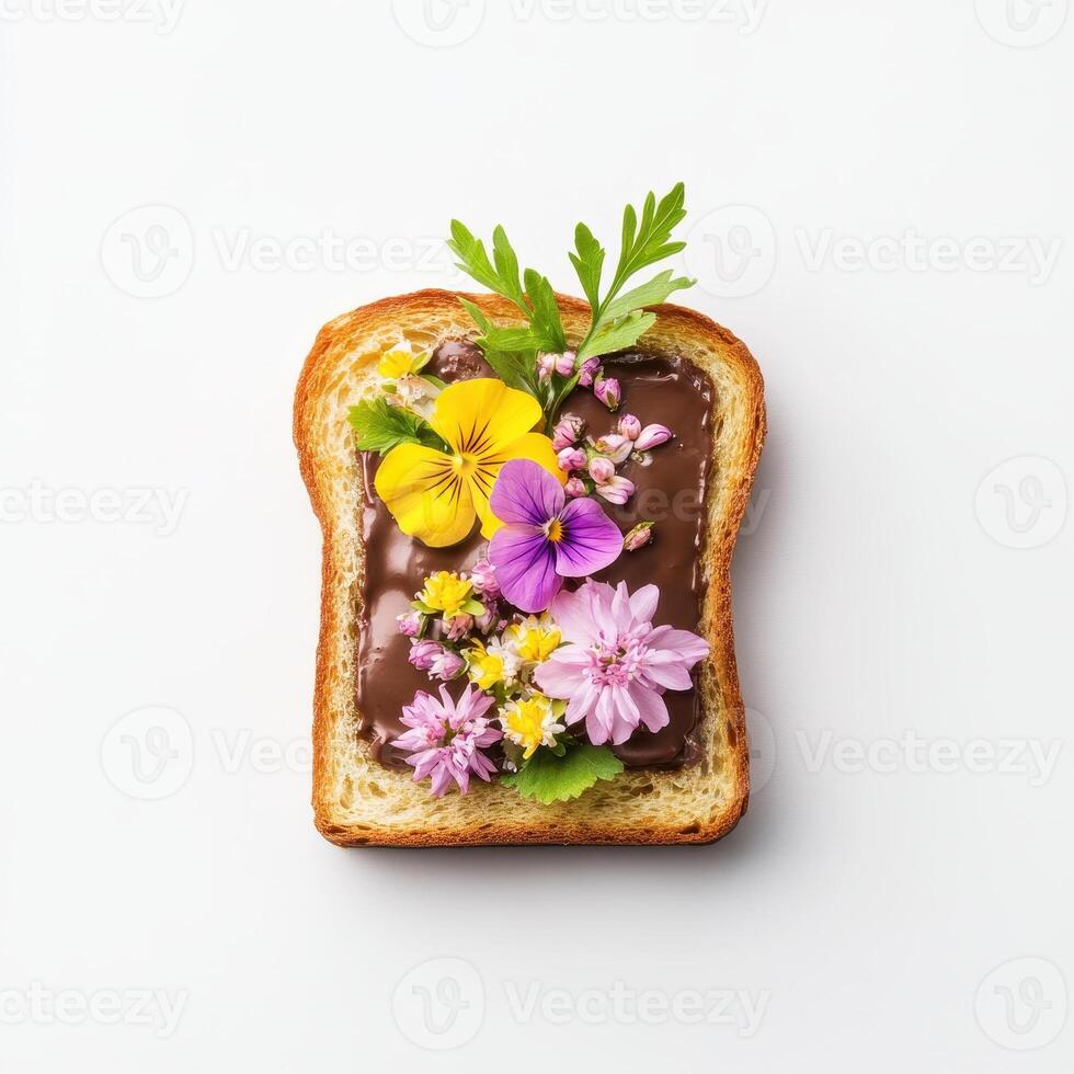 Toasted bread topped with chocolate ganache and colorful edible flowers photo