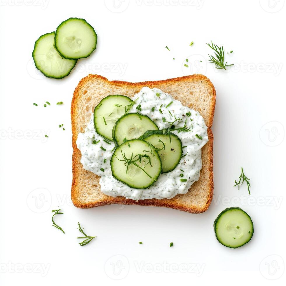 Toasted bread topped with tzatziki and fresh cucumber slices, garnished with herbs photo