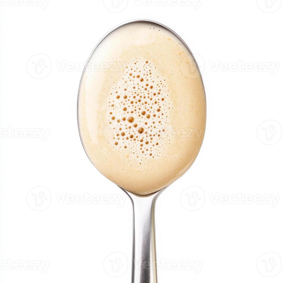 Creamy pancake batter in spoon, ready for cooking, showcasing texture and bubbles photo