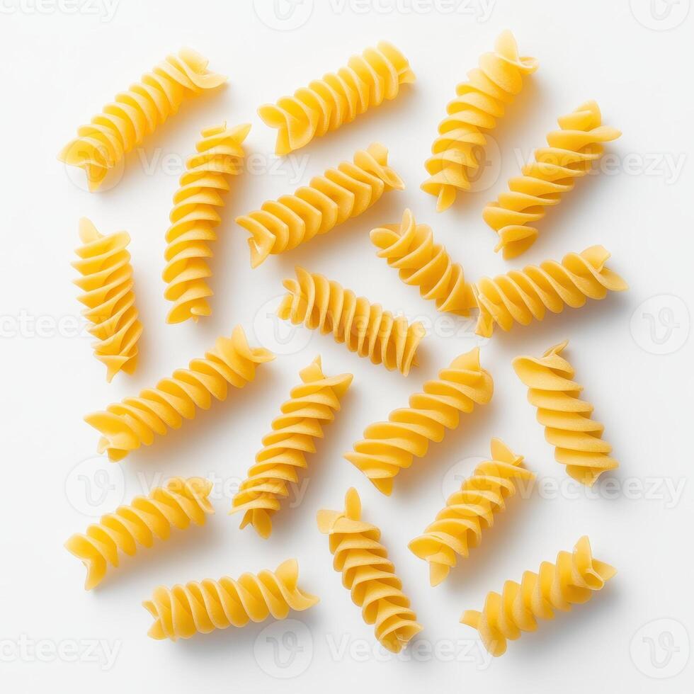 Uncooked fusilli pasta spirals scattered on white background, showcasing their unique shape and texture photo