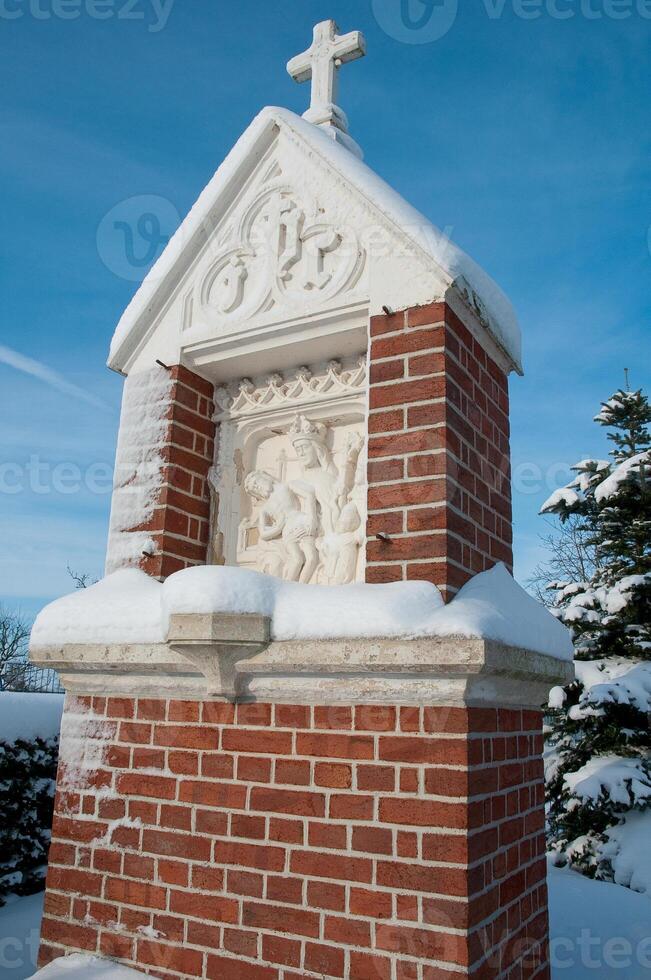 A small building with a cross on top of it photo