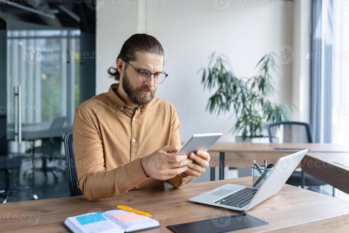 Business professional focusing on tablet usage at a neatly organized office desk workspace. photo