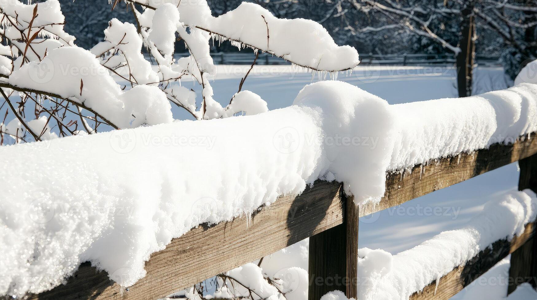 A fence covered in snow with a tree in the background photo