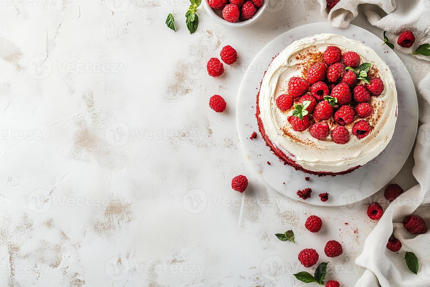 A cake with cream and raspberries on a white table photo