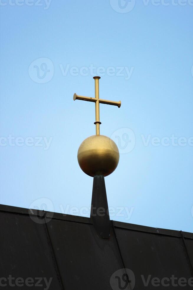 golden cross on top of a church in Greifswald, Mecklenburg-Vorpommern, Germany. photo