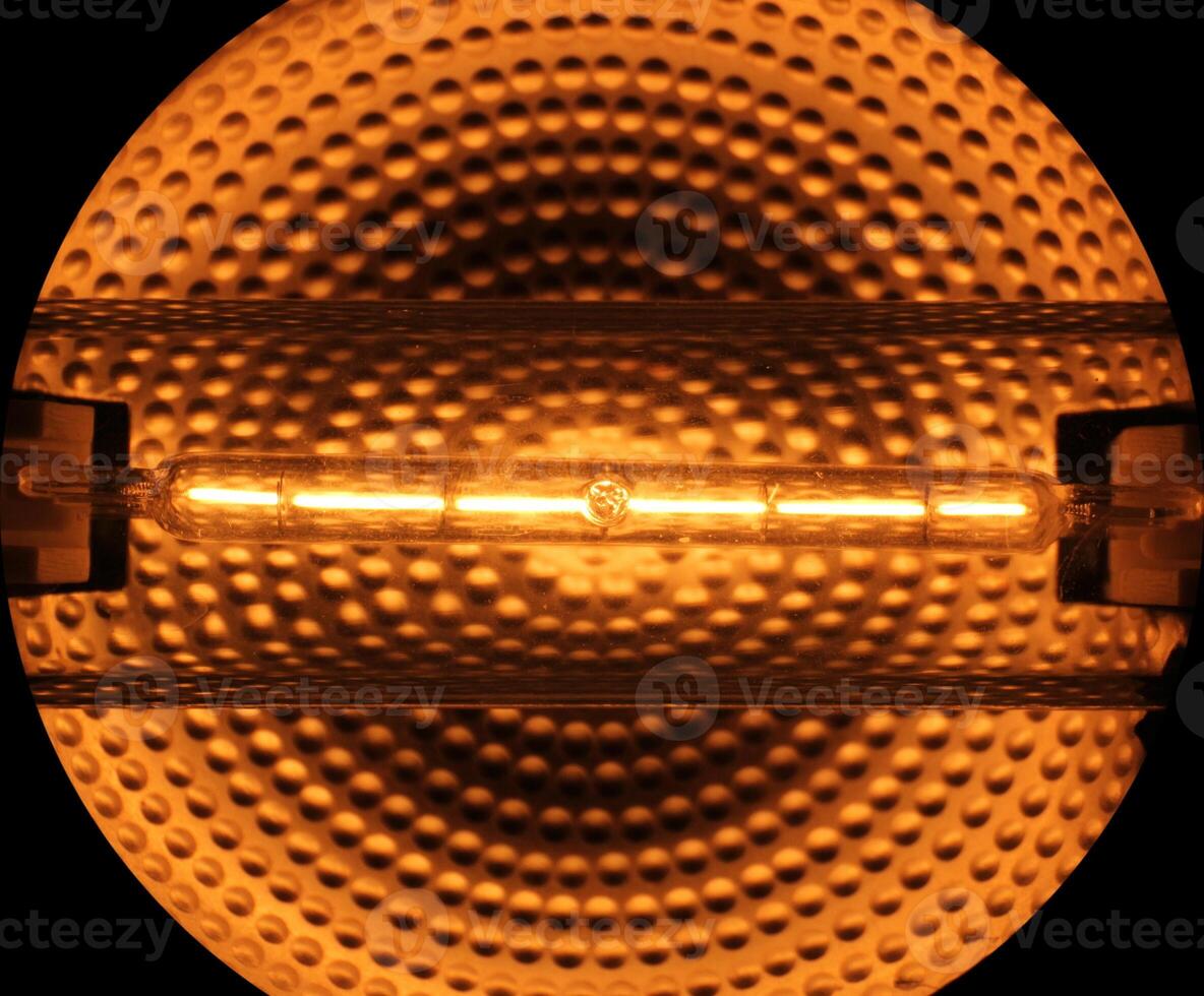 Halogen tube lamp with reflecting metallic background. photo