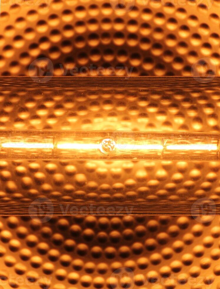 Halogen tube lamp with a reflecting background. photo