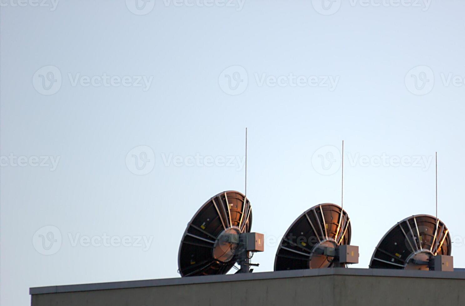 Dishes on a roof at sunset. photo