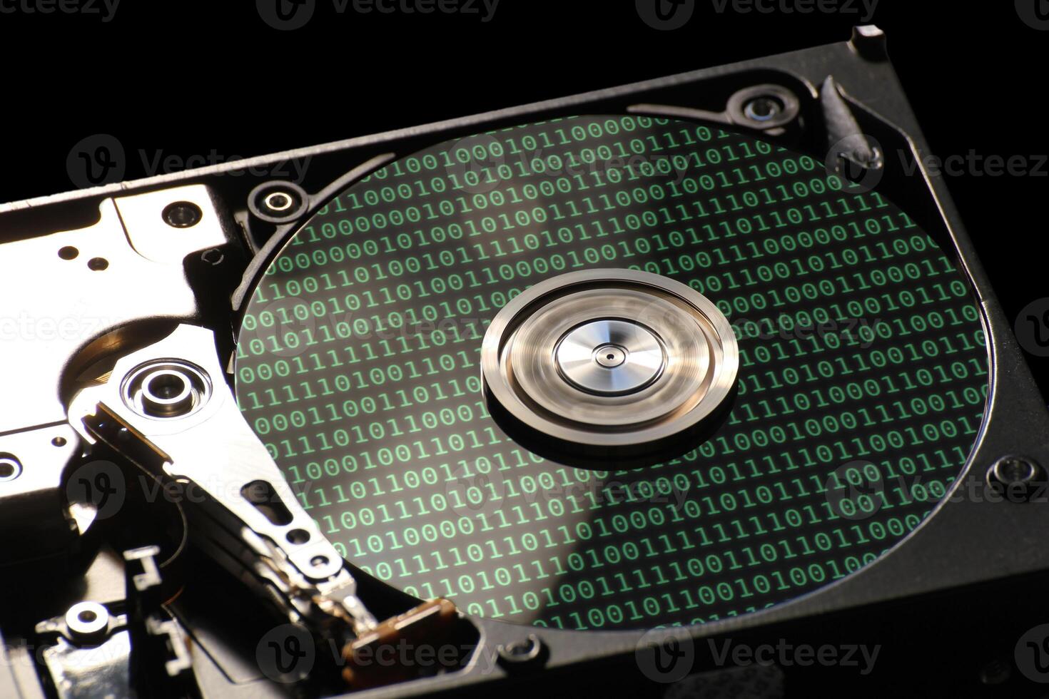 Hard disk on a black background with reflections on ones and zeros binary code. photo