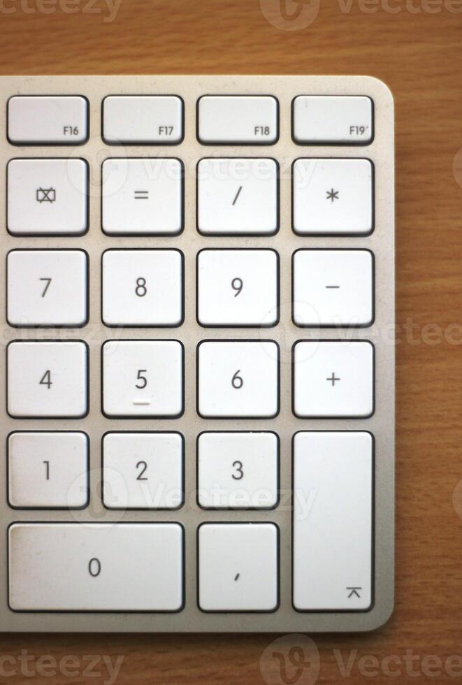 Numpad of an Apple keyboard on wooden desk photo