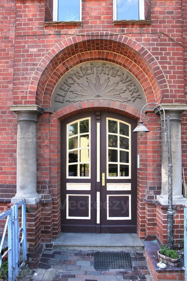 Front door of former electrical power station in Greifswald. Nowadays it is a residential building. The writing above the door says Eletricitts-Werk electrical power station photo