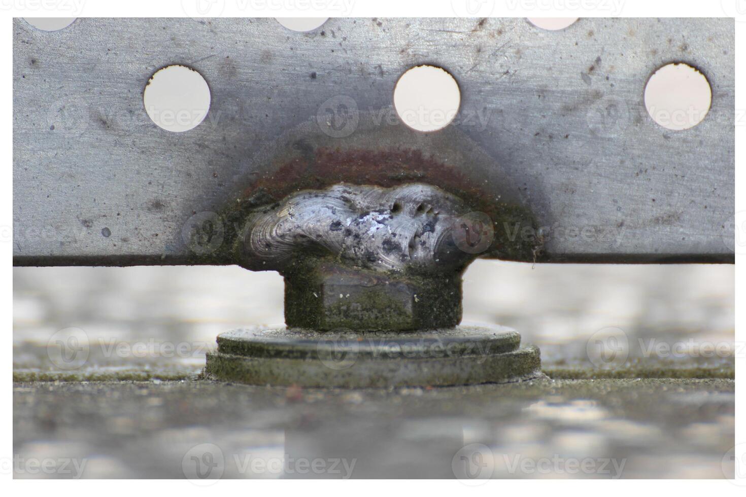 Close up of a weld seam holding metal panel with holes. photo