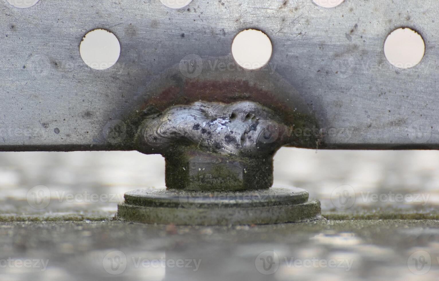 Close up of a weld seam holding metal panel with holes photo