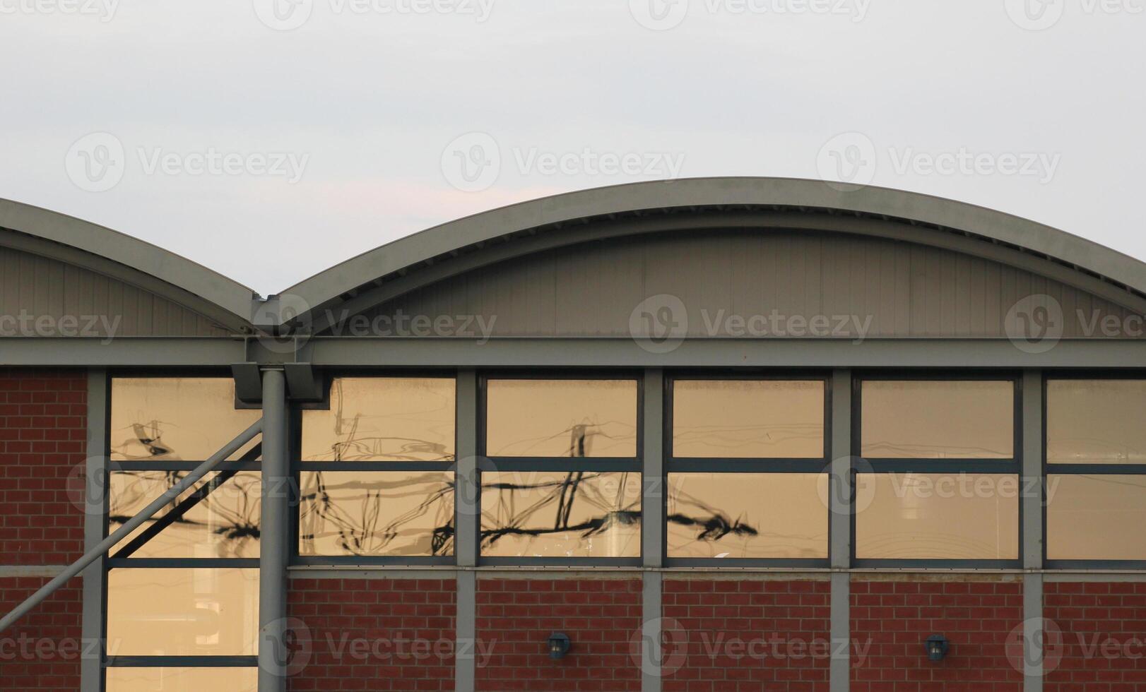 Windows with orange reflection of power line on an industrial building. photo