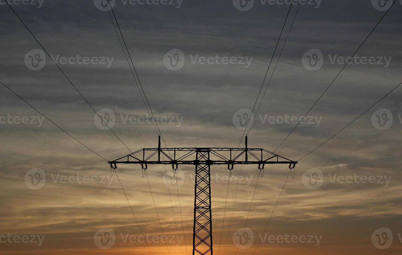 Symmetrical view on a high voltage power line during evening. The sky shows splendid colors. photo