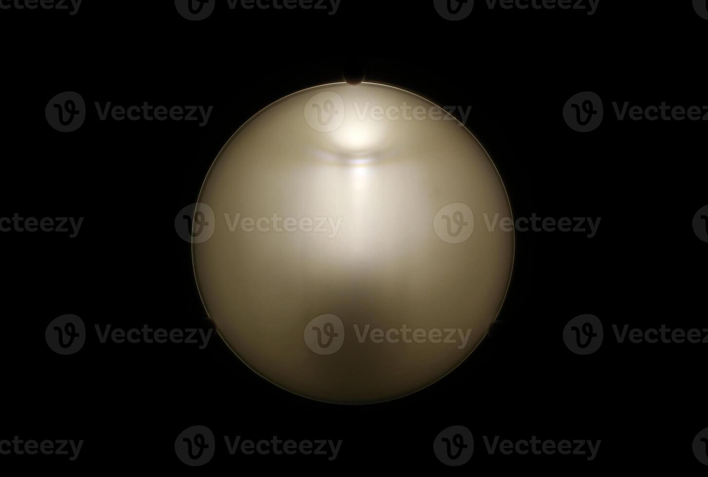 Abstract shot of lamp on black background. Some shapes can be seen on the shade. photo