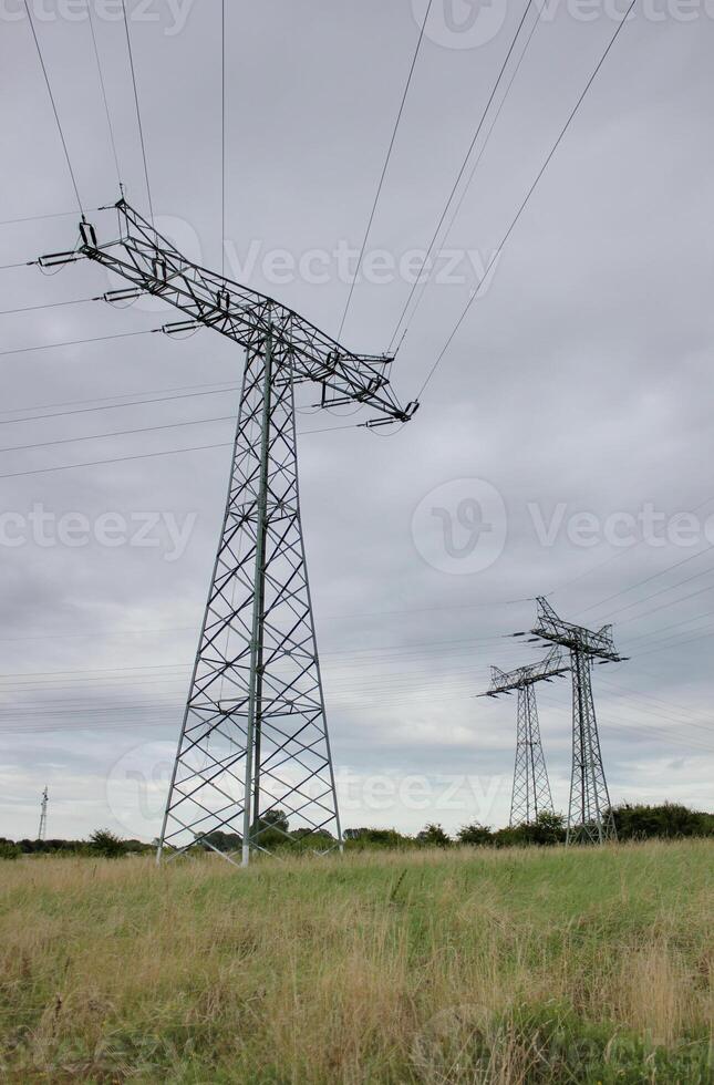 Three pillars of high voltage power lines in Mecklenburg-Vorpommern, Germany photo