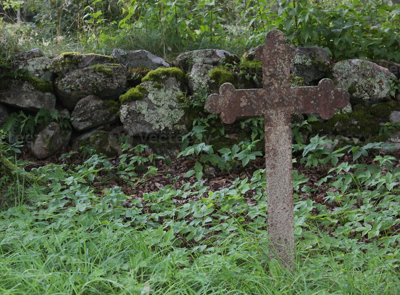 Old iron cross as tombstone besides a church ruin in Smaland, Sweden. photo