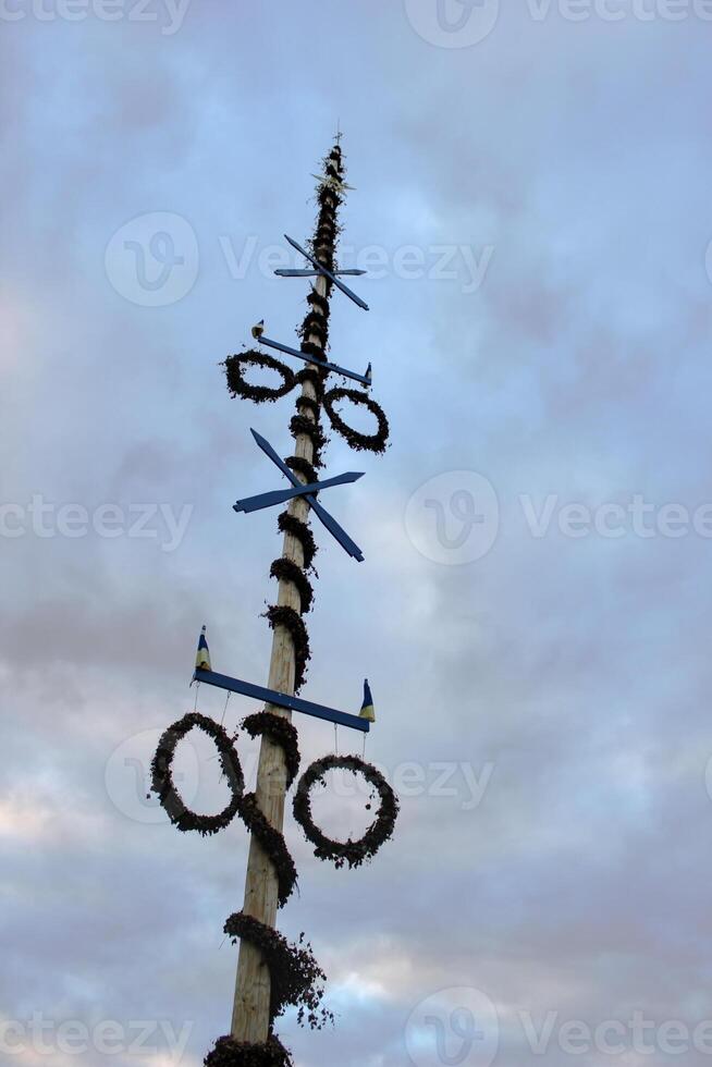 Traditional Swedish maypole in Dalarna. Dacing around a maypole is an activity that attracts many people celebrating midsummer. photo