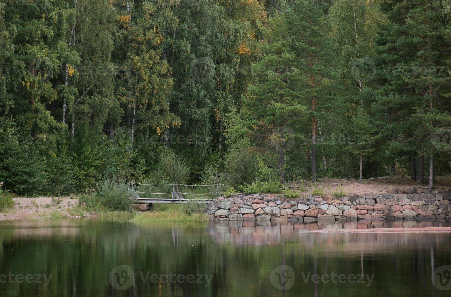 Edge of water with stones and a bridge in Sweden. photo