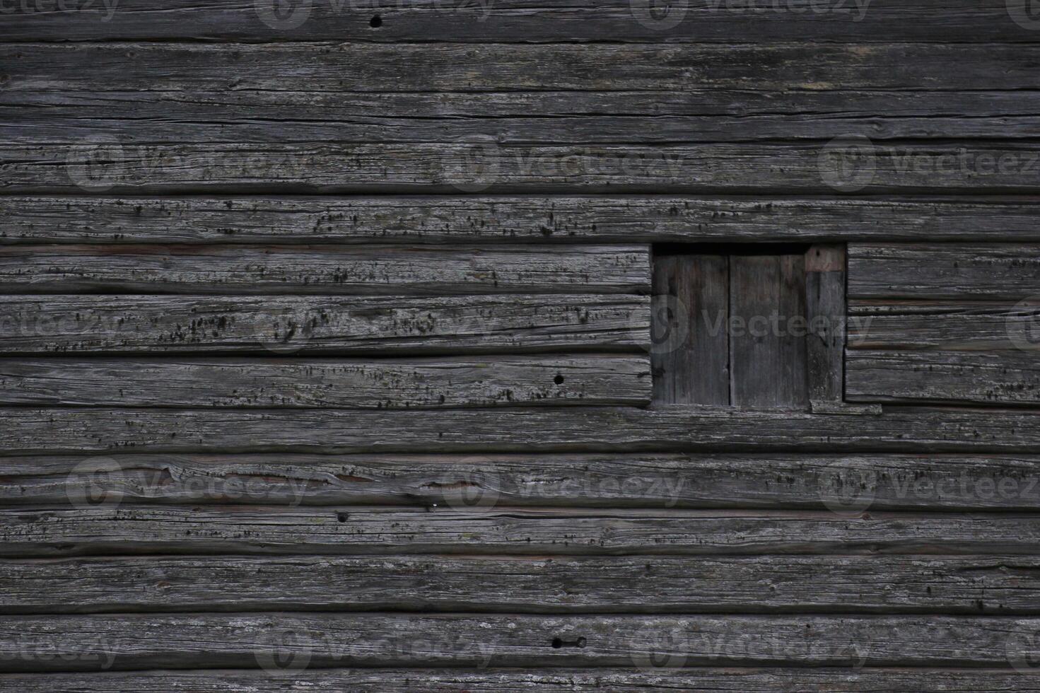 Dark wooden texture of log cabin with old window. photo