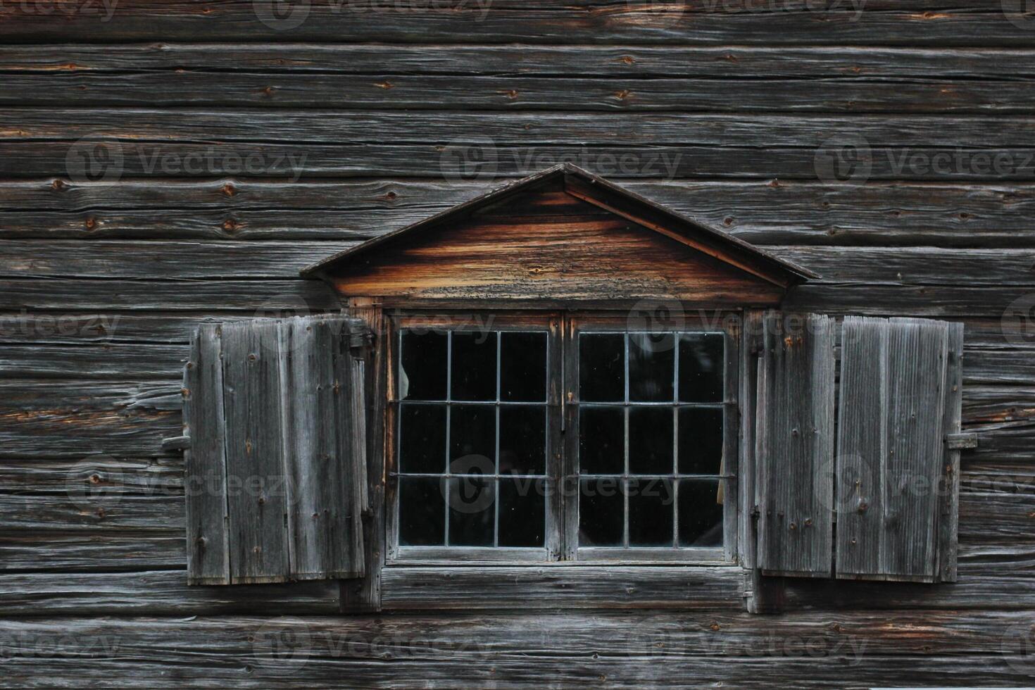 Dark wooden texture of log cabin with old window photo