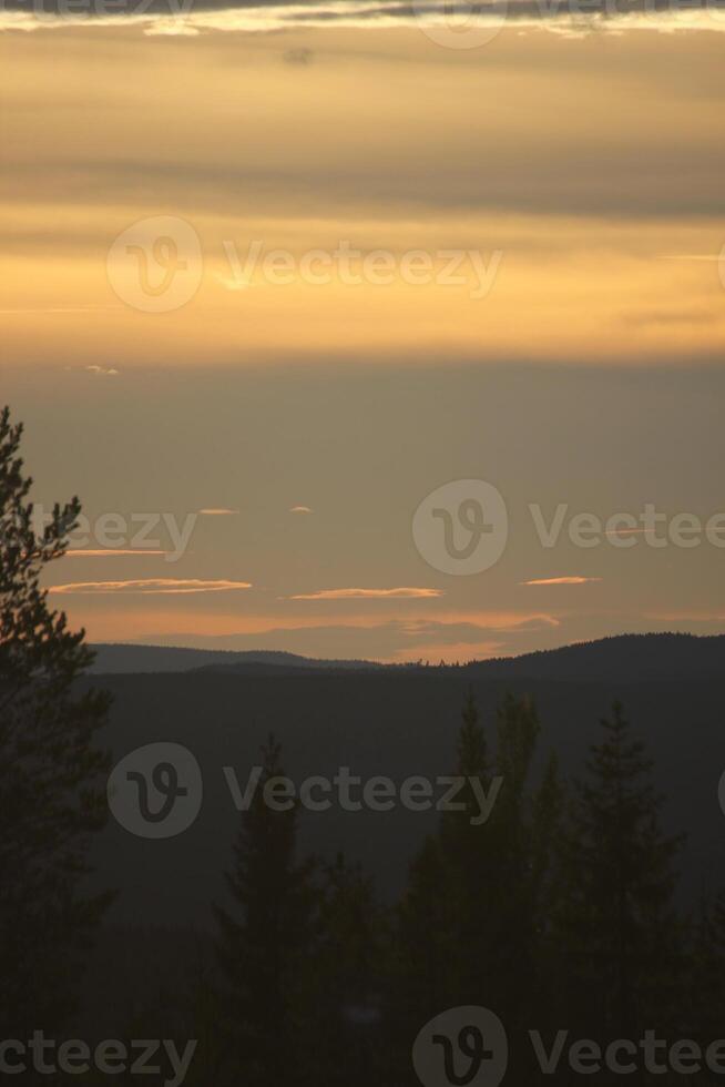 Sky with different shades of orange over a mountain silhouette in Sweden photo