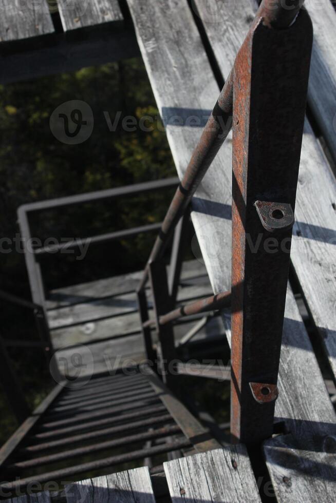 Looking down on steep and rusty ladder steps. photo