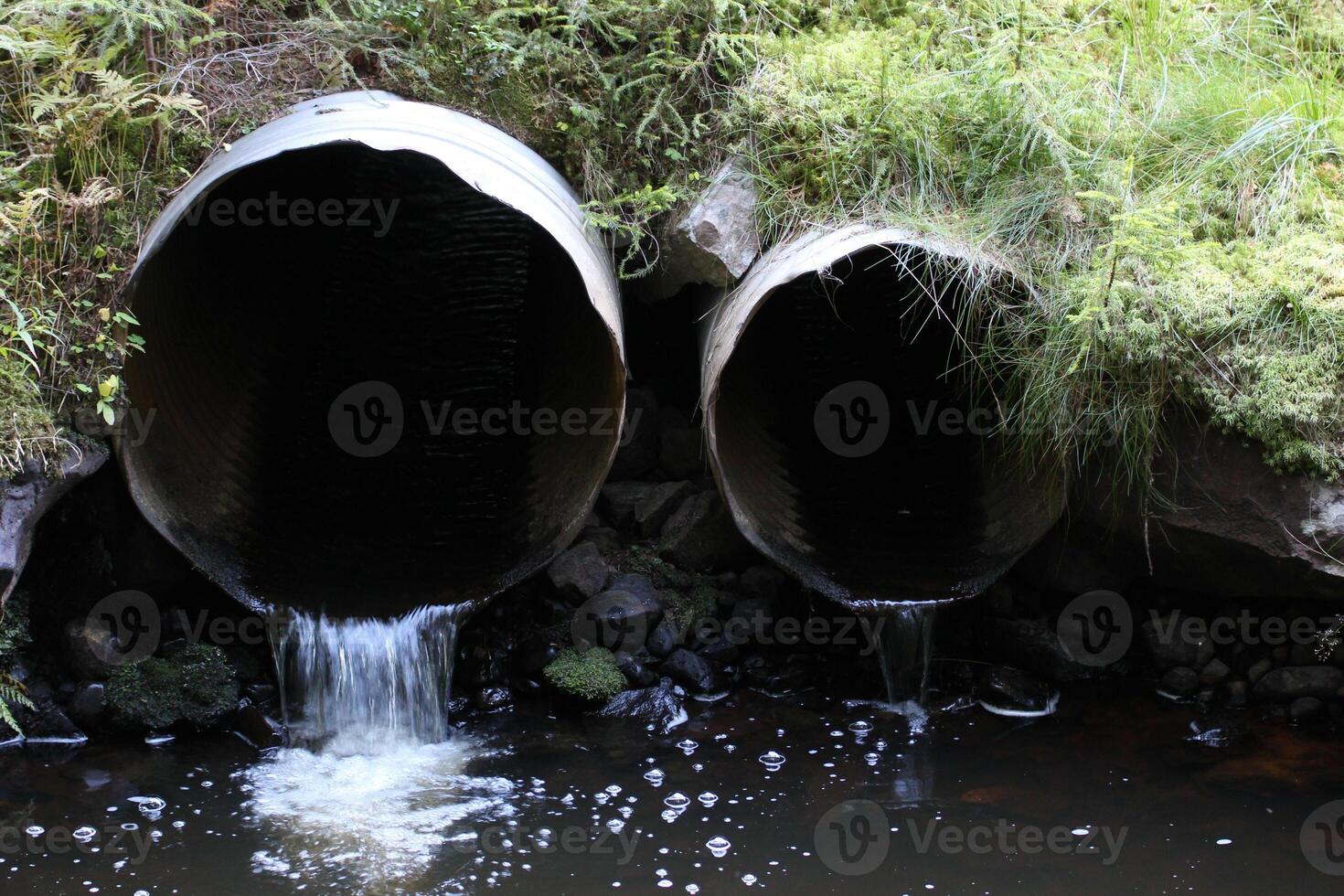 Small and big water pipe in a stream. photo