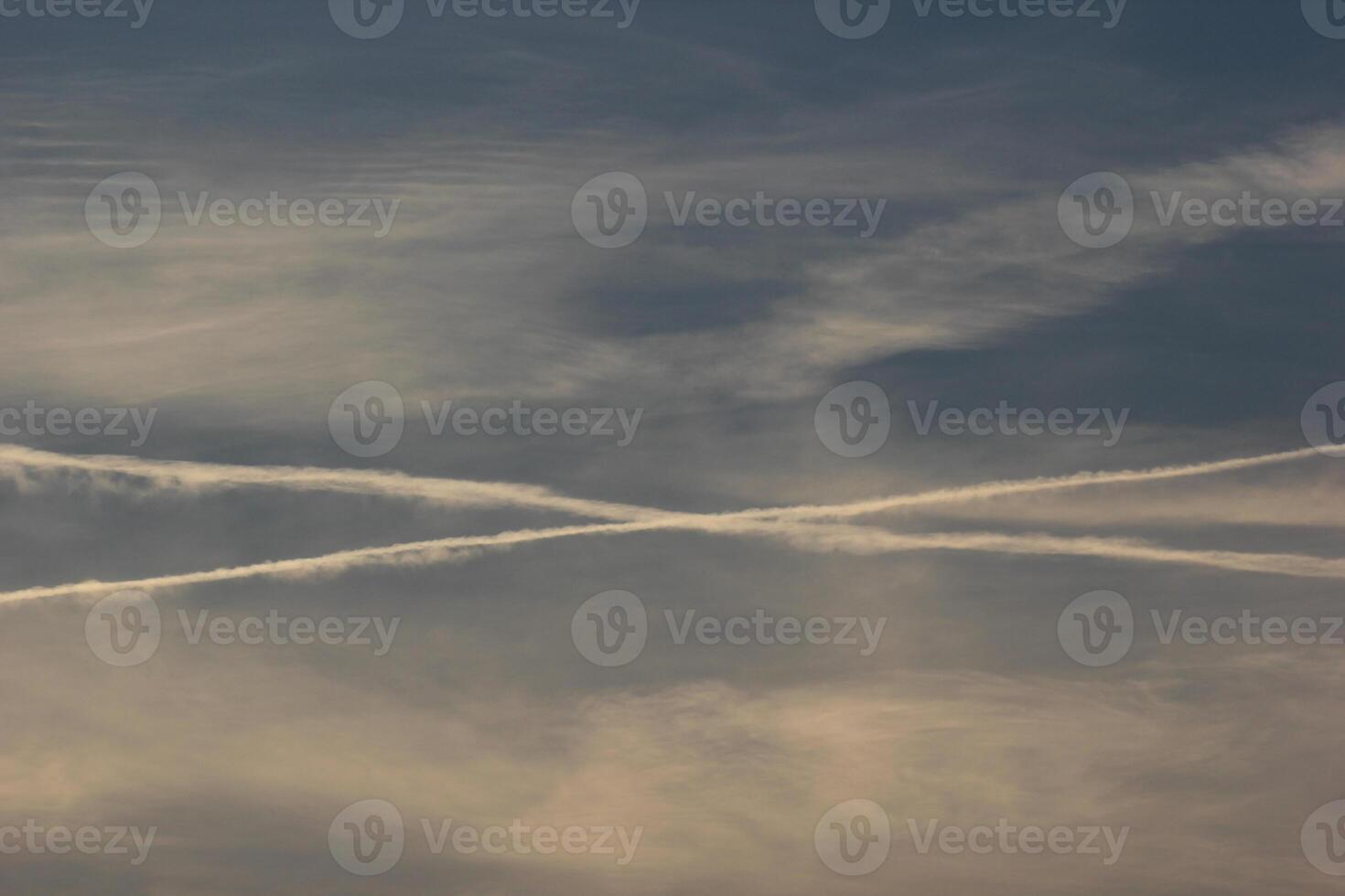 Evening cloudscape with crossing contrails. photo