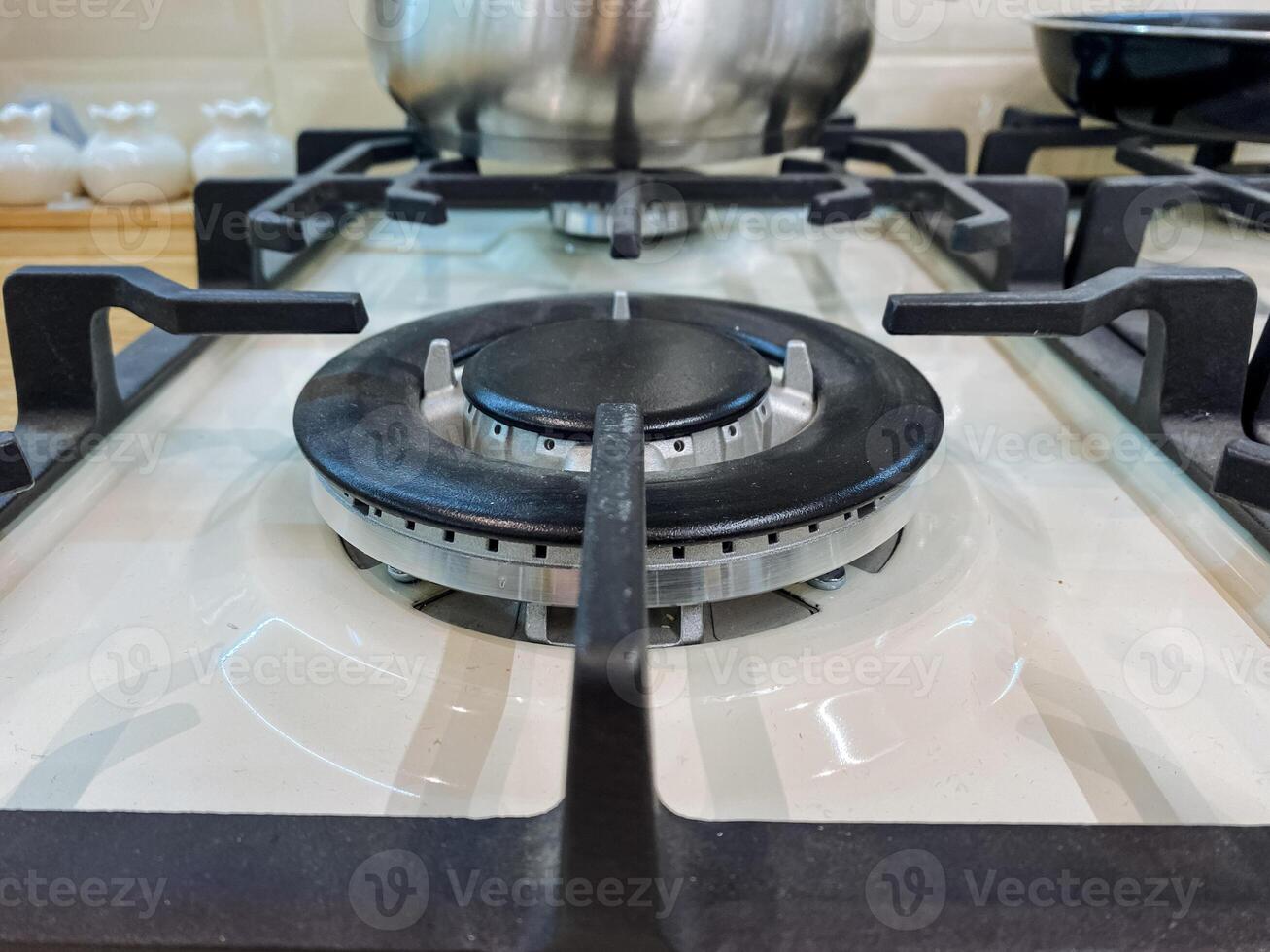 A pot is sitting calmly on a gas stove, which is a fundamental kitchen appliance created specifically for the purpose of cooking food by utilizing gas as the heat source to prepare meals photo