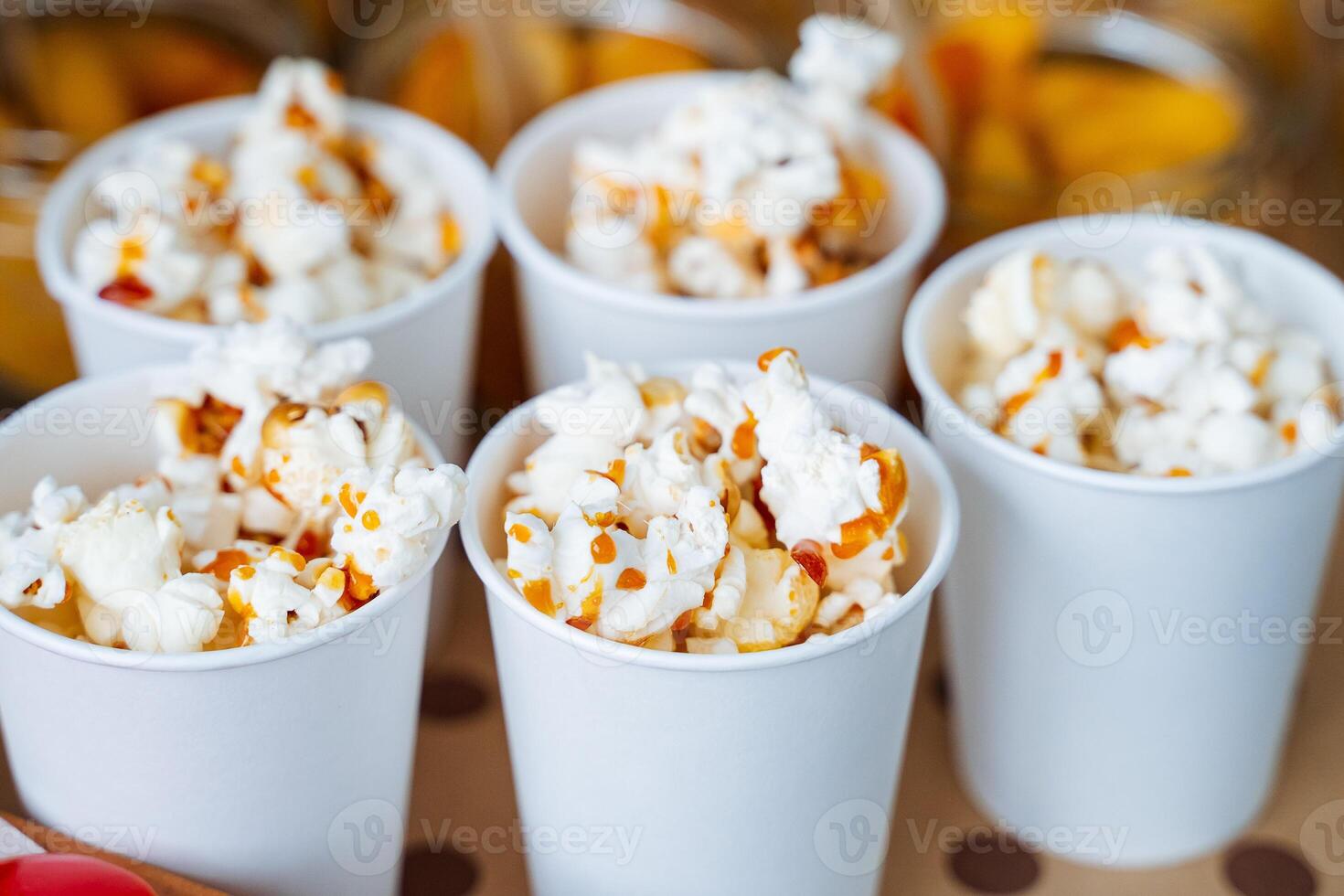 Experience the delightful taste of deliciously buttery popcorn, expertly served in cheerful, fun white cups, making it the perfect snack for your unforgettable movie night photo
