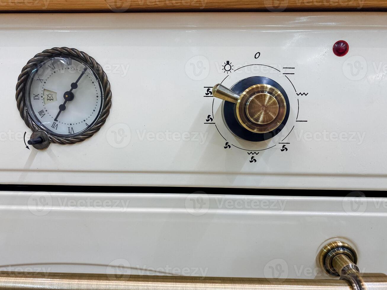A classic white stove featuring a gauge for monitoring and a knob for controlling the temperature, making it a functional and essential home appliance for cooking and baking photo