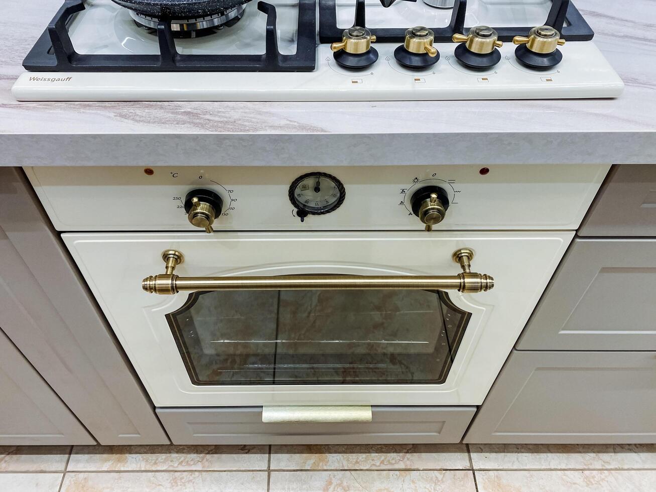 In a warm and inviting kitchen, a stylish sleek white oven is elegantly placed atop a modern gas stove, significantly enhancing both functionality and overall style within the cooking space photo