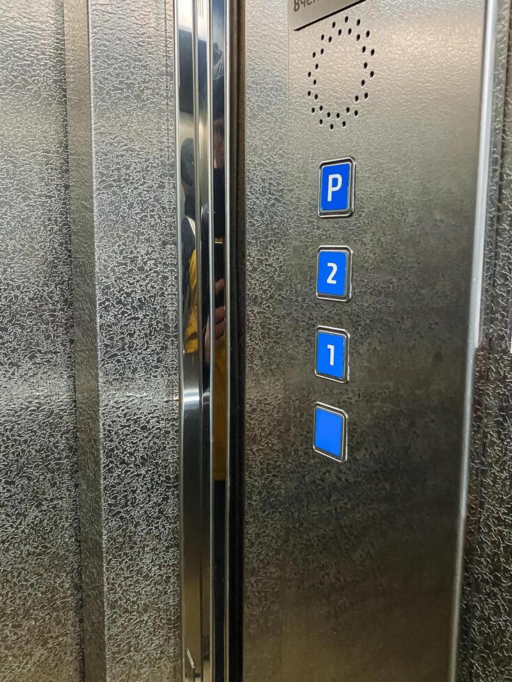 This stainless steel elevator features blue buttons labeled for parking P, second floor 2, and entrance level 1, ensuring efficient control of the buildings floors photo