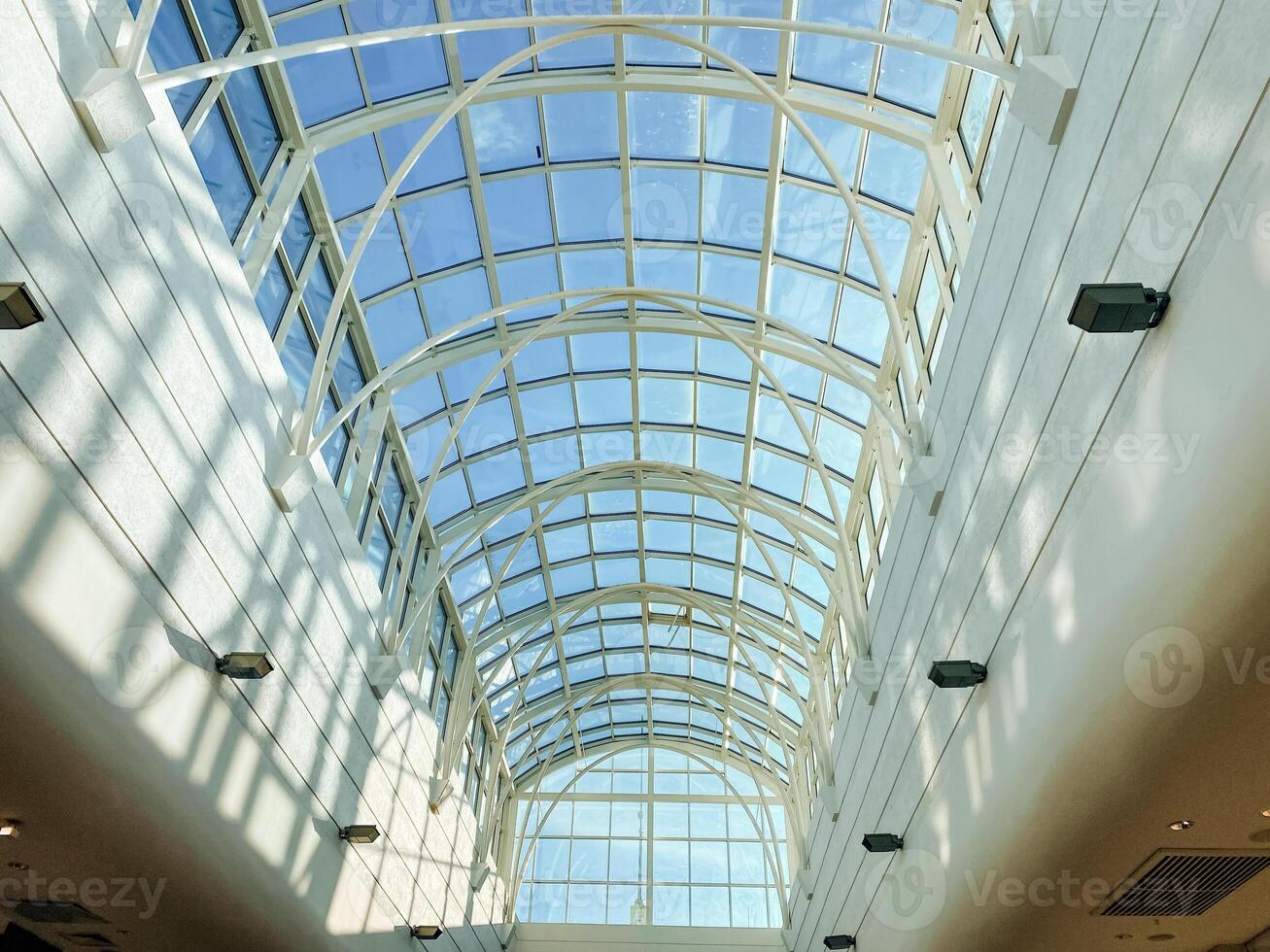 Under the stunning glass ceiling, I am captivated by the intricate architecture that reflects the vibrant urban landscape, enhancing the elegance of the entire metropolitan area photo