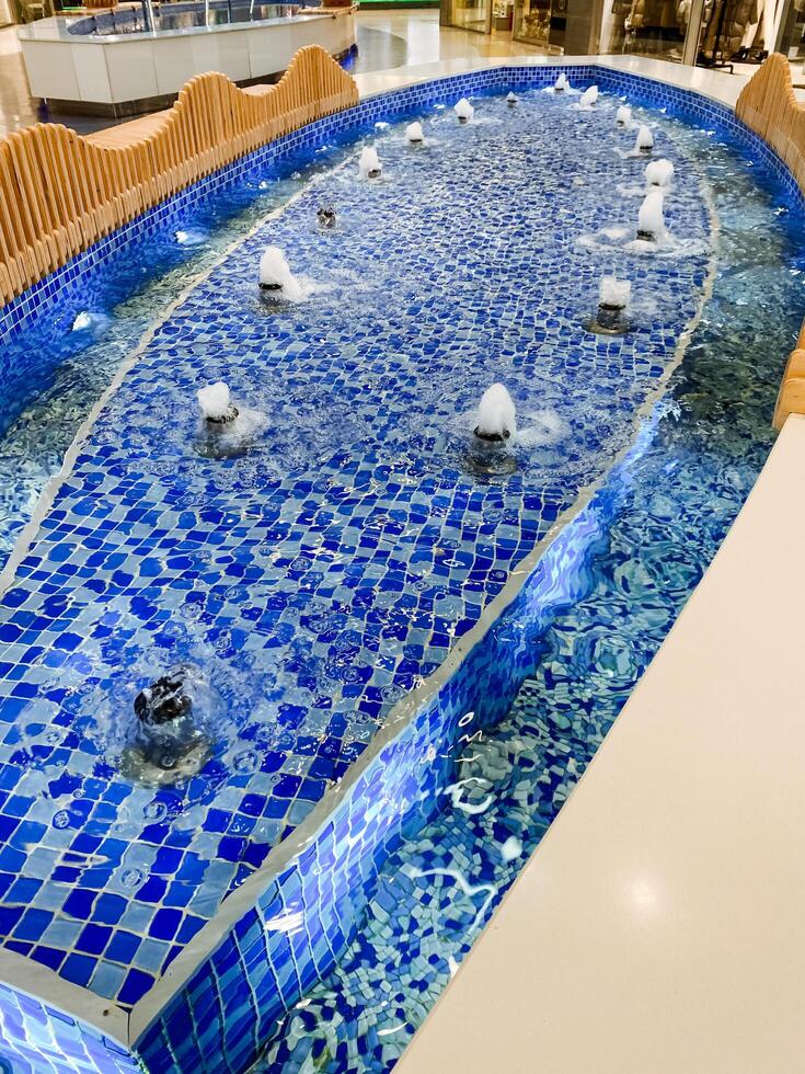 There is a unique fountain located within the shopping mall that remarkably resembles a coffin, making it a striking piece of art that draws attention from all who visit photo