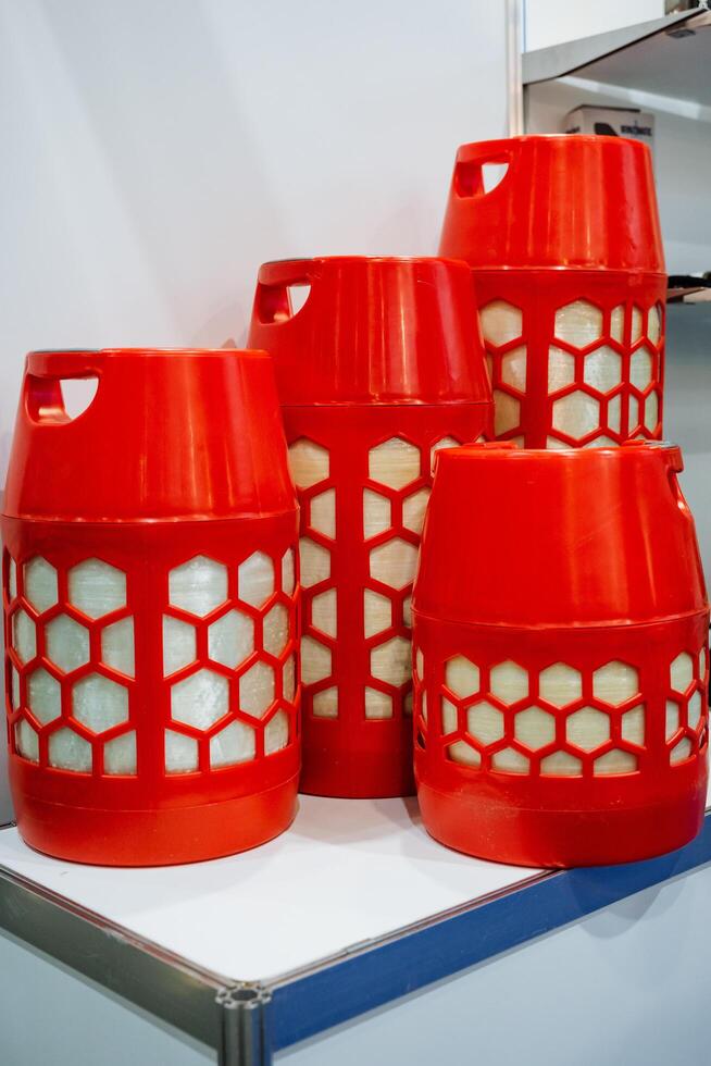 A collection of bright red plastic containers, arranged in a neat stack on top of one another, is resting on a table, creating an interesting visual display of color and form photo
