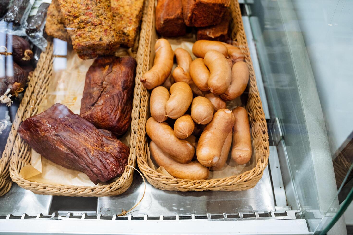 A beautifully arranged display case filled with an enticing variety of meats, including different types of sausages, showcasing the culinary delights available to customers photo