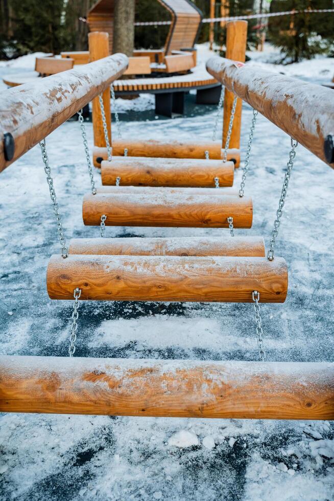 A beautifully crafted wooden bridge stands majestically, completely blanketed in a thick layer of snow and glistening ice, creating a stunning winter scene in the natural landscape photo