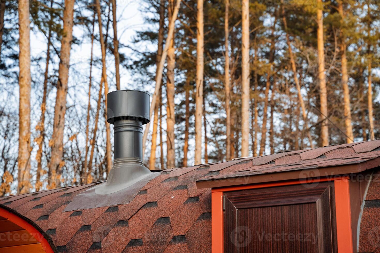 In the midst of a dense and vibrant forest, there stands a charming wooden barrel complete with a rustic chimney extending from its roof, creating a unique and picturesque scene photo