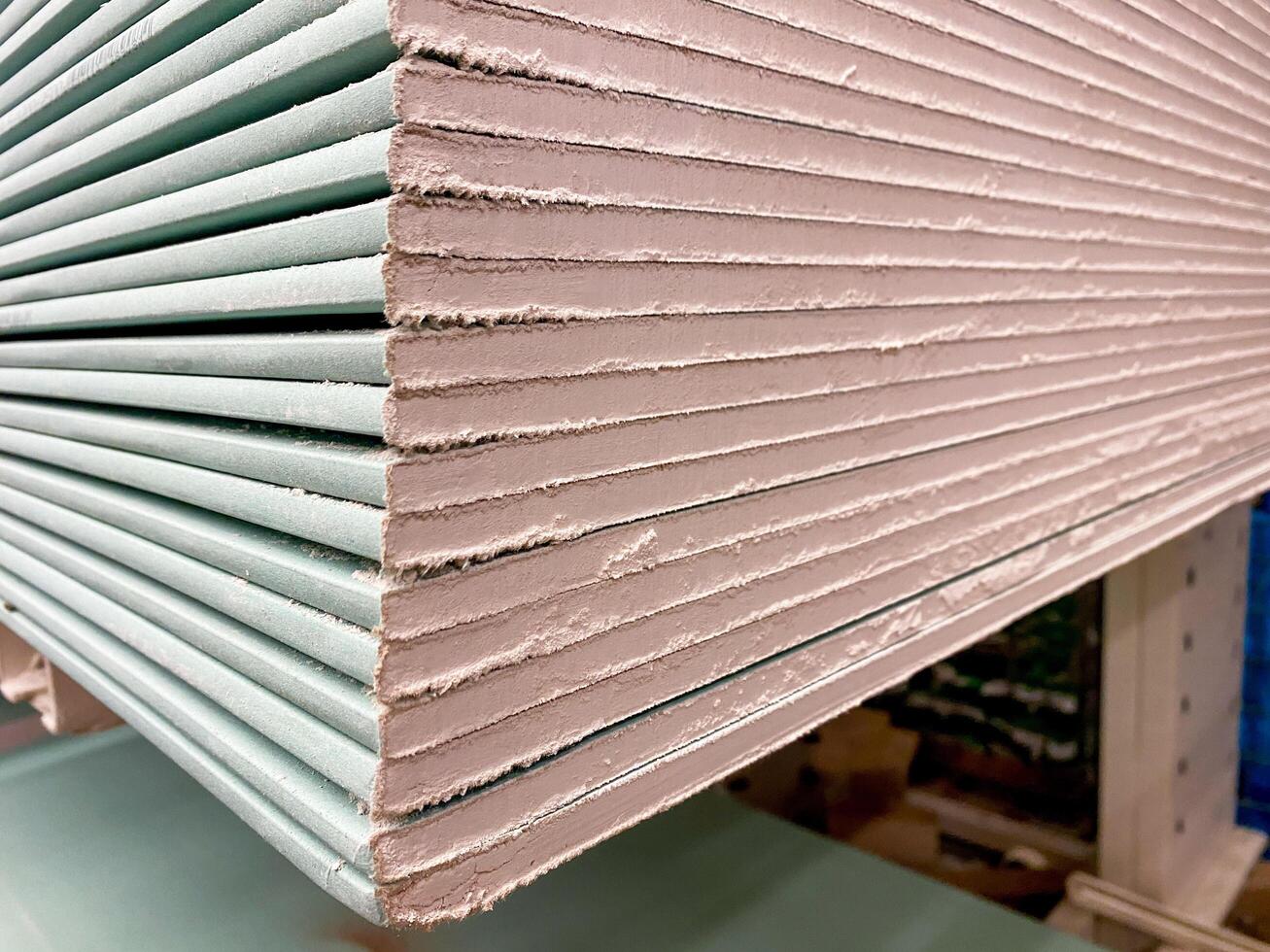 This highquality image provides a detailed and closeup view of a taller stack of essential drywall sheets that are commonly used in construction and various interior finishing projects photo
