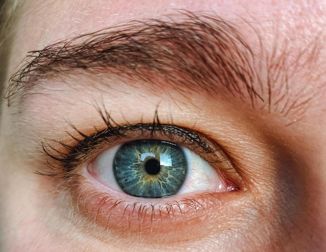 This image captures a stunning closeup view of an individuals mesmerizing blue eye, showcasing the intricate details and vivid color that make it truly captivating, illustrating beauty photo