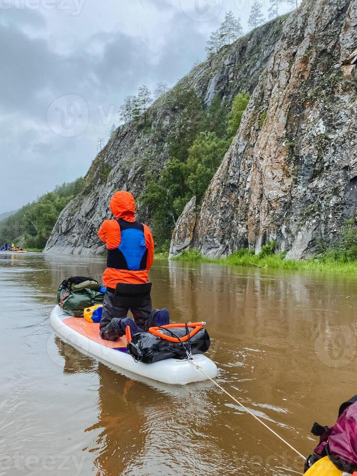 A man is leisurely pulling a kayak down a calm river, fully enjoying a tranquil day on the serene lake while also finding a deep connection with the beauty of nature surrounding him photo