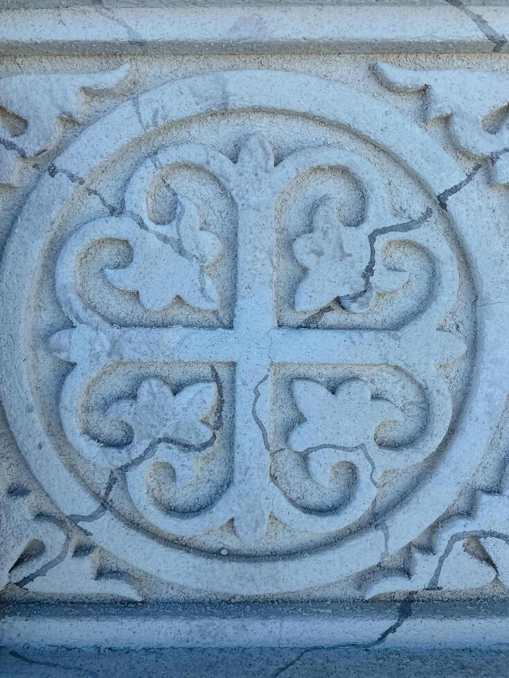 This is a fascinating stone carving featuring a distinct circular shape that is adorned with four beautifully designed hearts located within it, creating an intriguing design photo