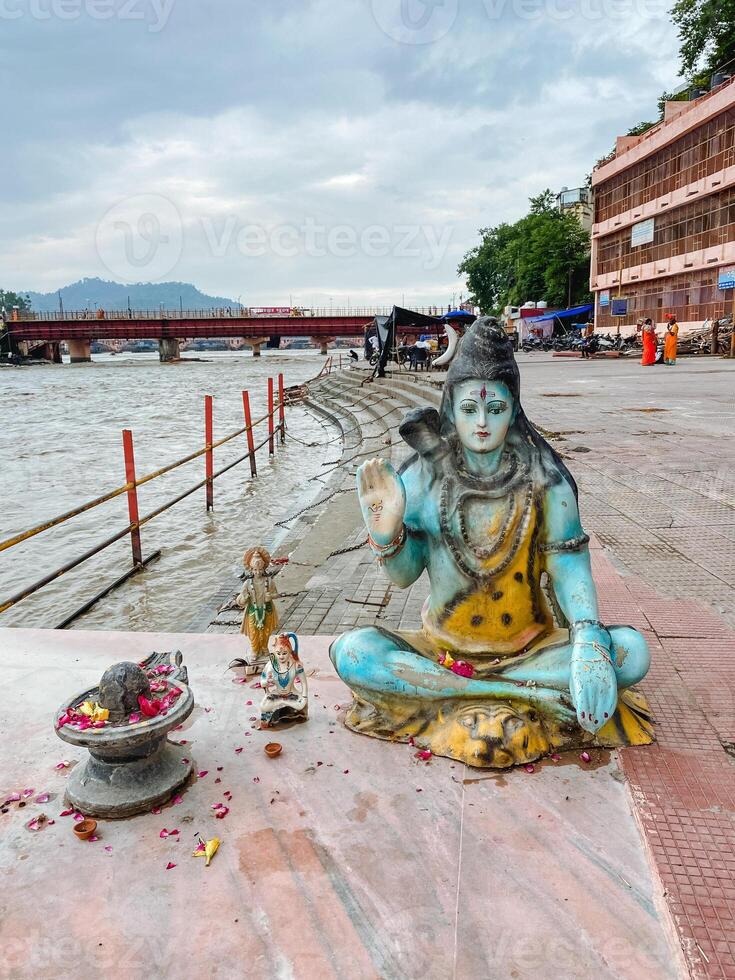 A peaceful, serene riverside scene features a beautiful Shiva idol situated gracefully at the scenic Ganges riverbank, embodying devotion photo